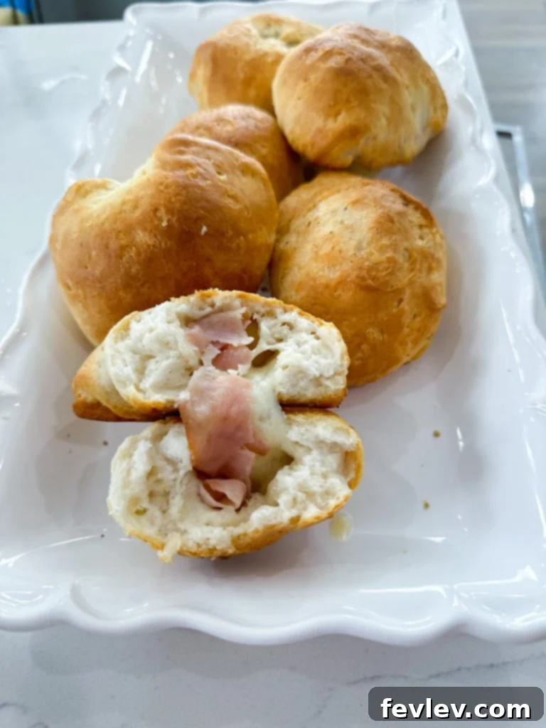Stuffed Ham and Cheese Biscuits arranged on a plate with fresh parsley for garnish.