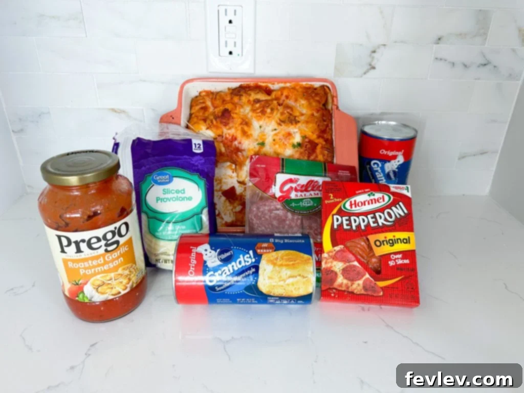Ultimate Italian Sub Bake 2 A top-down view of an unbaked Italian Sub Casserole, showing chopped biscuits, meats, cheese, and marinara sauce mixed together in a large casserole dish, ready for the oven.