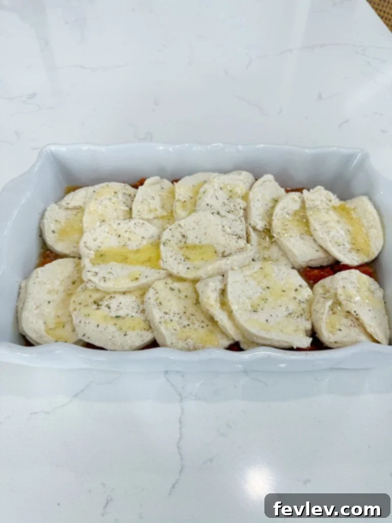 Italian sausage and vegetable filling spread evenly in a baking dish