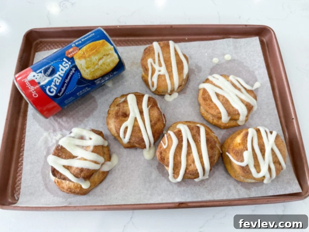 Cinnamon Swirl Biscuits 3 Ingredients laid out for making Cinnamon Roll Biscuits, including a can of refrigerated biscuits, cinnamon, sugar, cream cheese, powdered sugar, and milk.