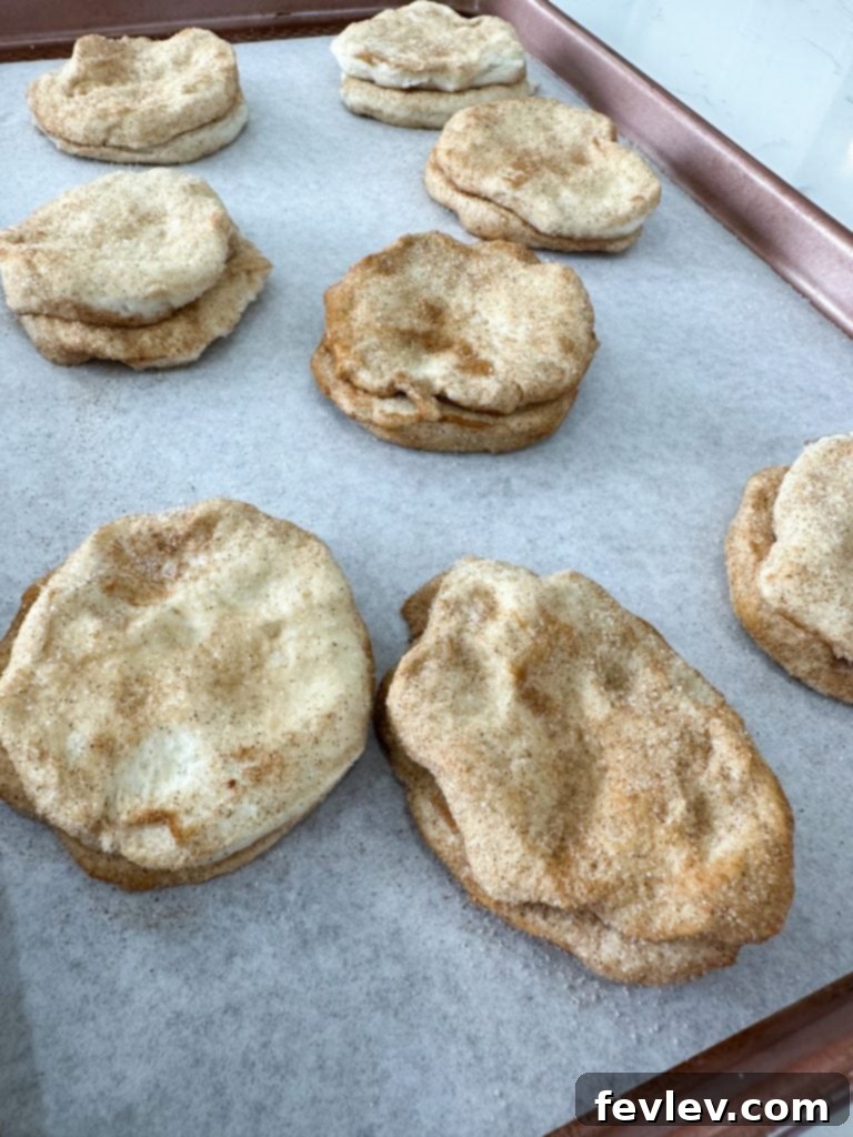 Cinnamon Swirl Biscuits 4 Biscuits being split in half and coated with cinnamon sugar, a key step in preparing Cinnamon Roll Biscuits.