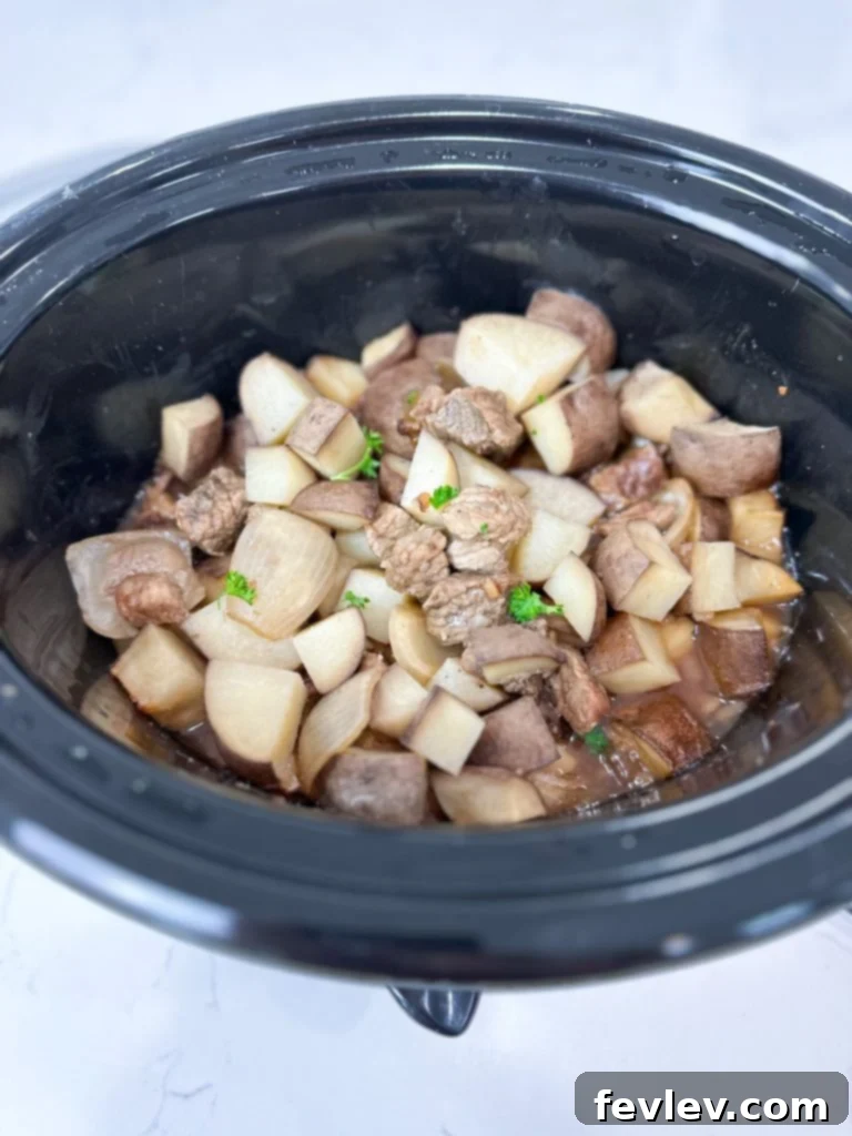 Plated slow cooker garlic steak bites with fresh parsley garnish