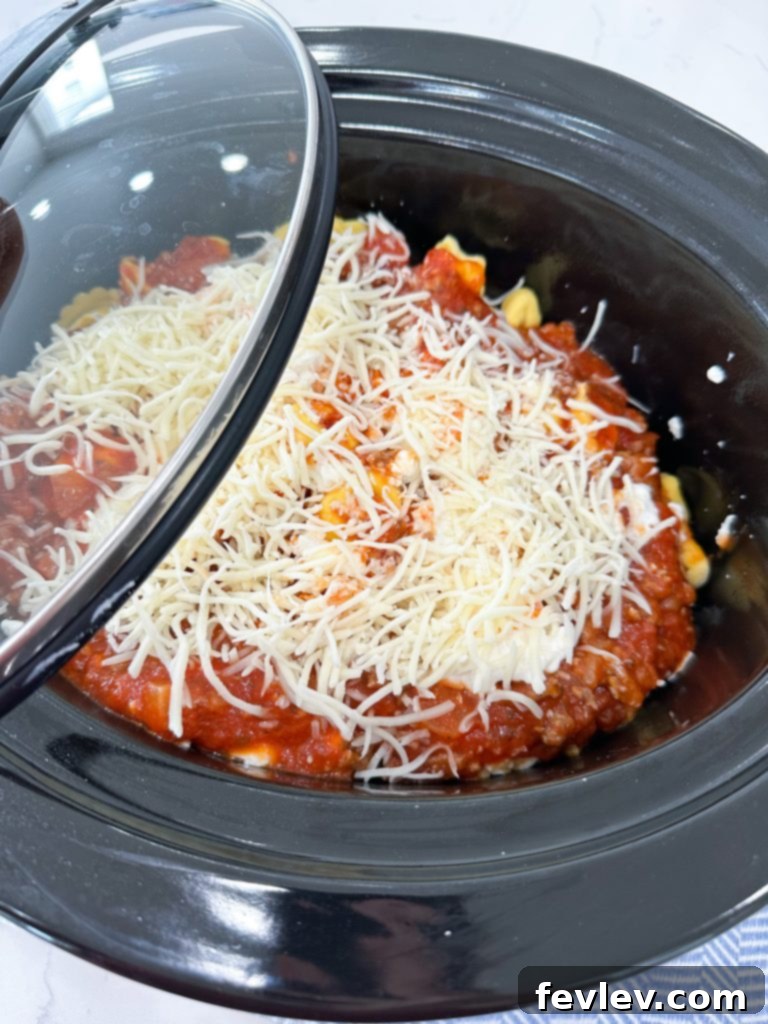 The Ultimate Slow Cooker Sausage Tortellini Bake 6 Layering tortellini, sausage sauce, and cheese in a slow cooker