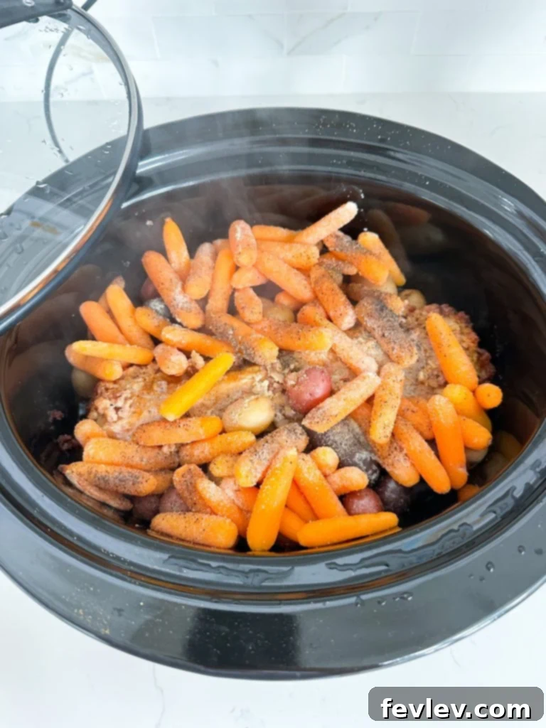 Melt-in-Your-Mouth Slow Cooker Pork Tenderloin 5 Slices of juicy slow cooker pork tenderloin plated beautifully with tender potatoes and carrots.