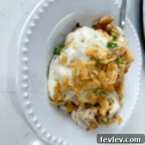 A beautifully plated serving of Slow Cooker French Onion Chicken and Rice, garnished with fresh herbs, in a deep bowl, ready to be enjoyed.