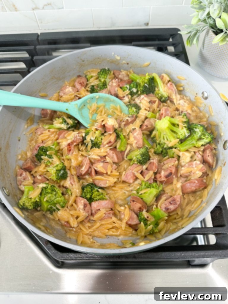 Close-up of fresh ingredients for Chicken Sausage Orzo Skillet, including raw chicken sausage, broccoli, and garlic.