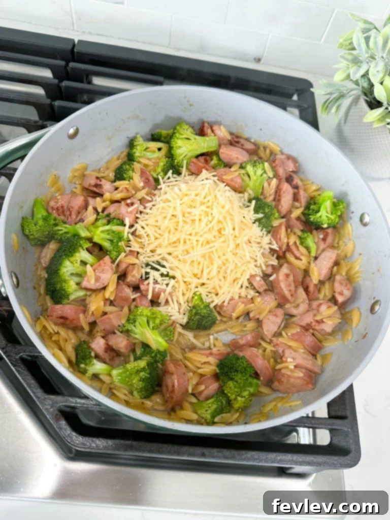 The One-Pot Chicken Sausage Orzo Skillet simmering, covered, allowing the orzo to cook and absorb the savory broth.