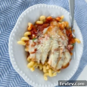 A dish of Chicken Mozzarella Pasta with melted cheese and sauce, ready to be served.