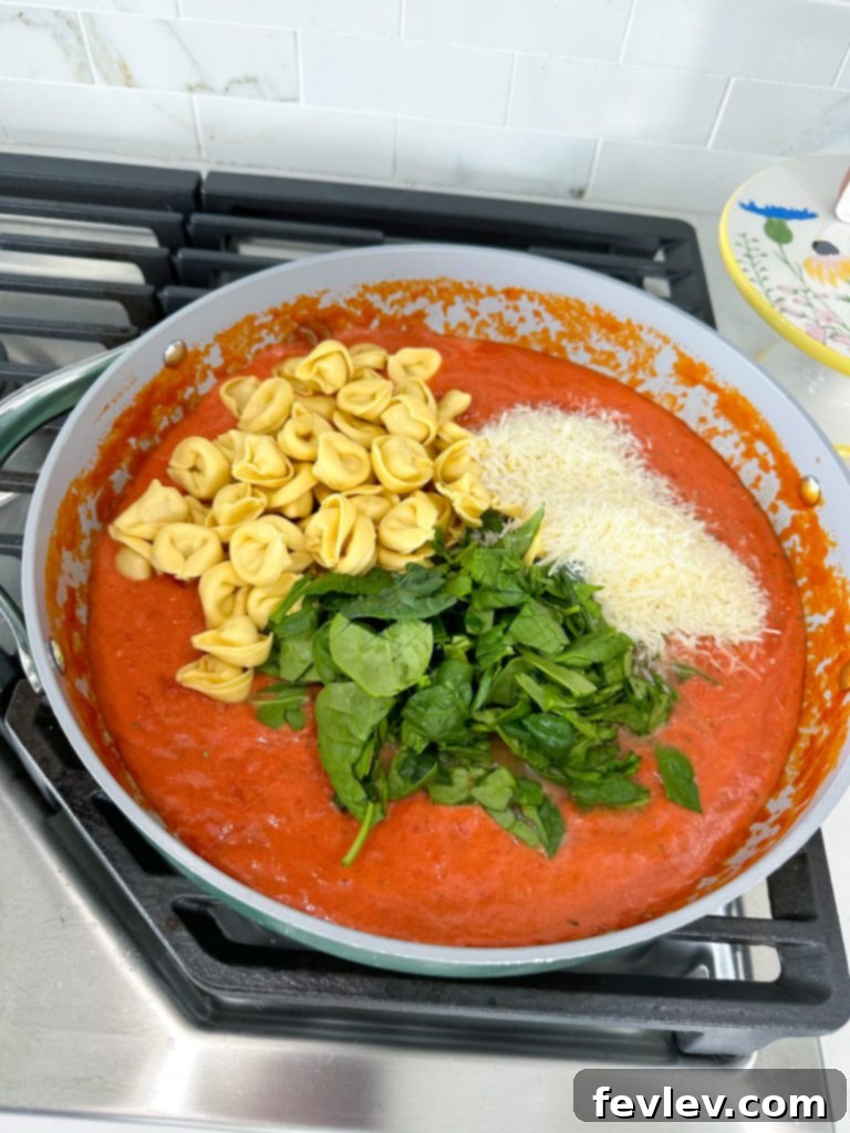 Adding crushed tomatoes and heavy cream to skillet