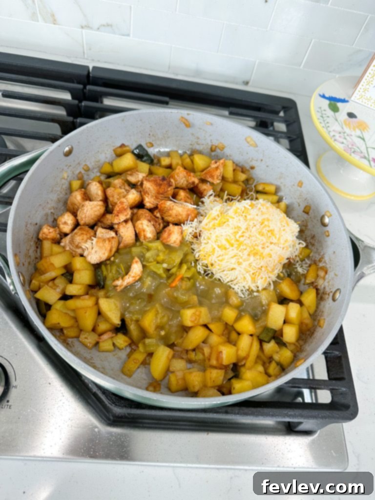 chicken searing in a skillet for green chile chicken with potatoes