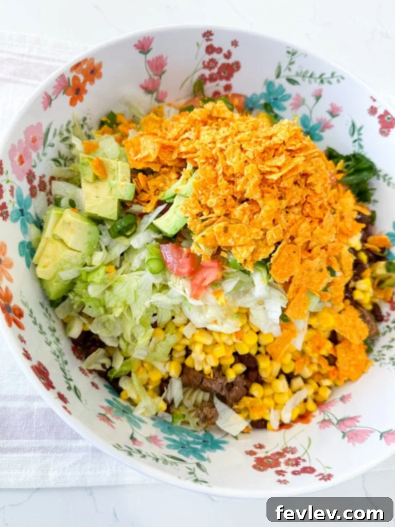 Nacho Taco Pasta Crunch 3 A close-up of fresh ingredients for Doritos Taco Pasta Salad, including raw beef, pasta, and vegetables.