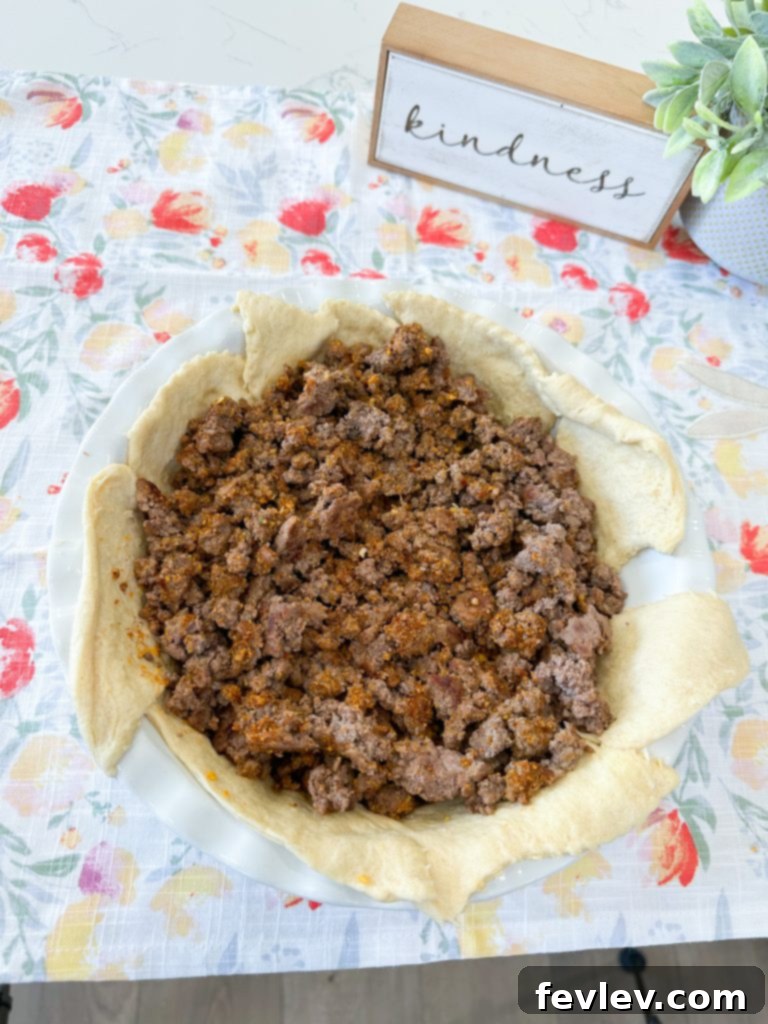 Crescent dough laid in a pie dish with crushed Doritos on top
