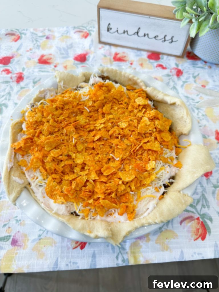 Shredded cheese and more Doritos layered on top of the pie filling