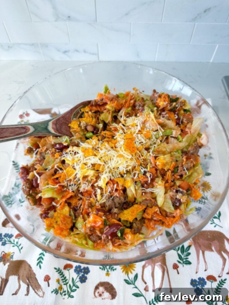 Catalina Doritos Taco Salad 2 A vibrant bowl of Taco Salad with Catalina Dressing and Doritos, featuring seasoned ground beef, crisp lettuce, chopped tomatoes, avocado, and a generous sprinkle of crushed Doritos.