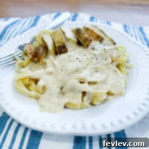 Velvety Chicken Fettuccine Alfredo 2 A beautifully plated dish of Classic Chicken Fettuccine Alfredo with perfectly seasoned chicken and a rich, creamy sauce.