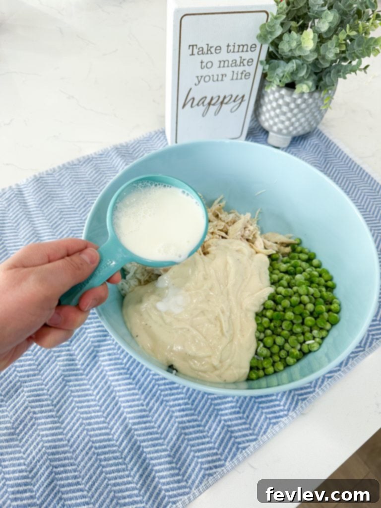 Jarred Alfredo sauce being poured over ingredients