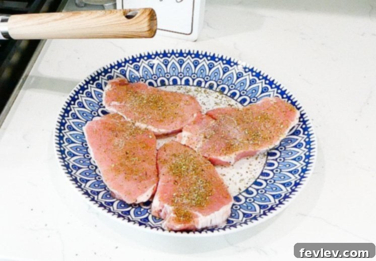 Plated seared pork chop with resting juices.