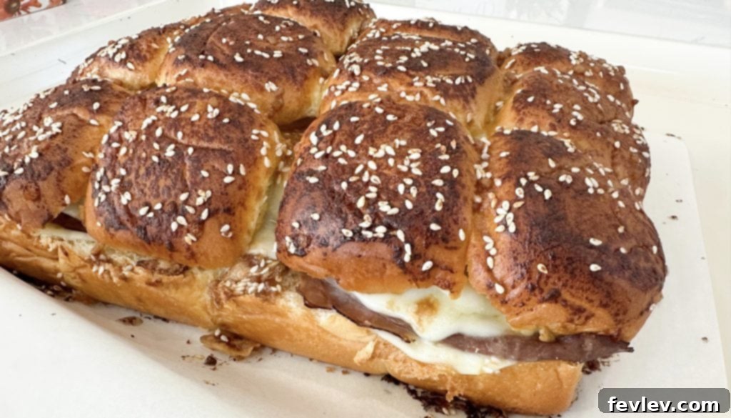 French Dip Sliders on a serving platter with au jus for dipping