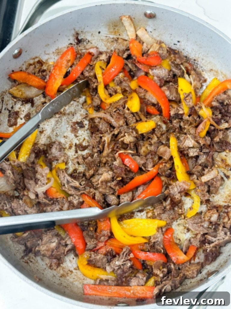 Cooking steak and vegetables in a large skillet for fajita quesadillas