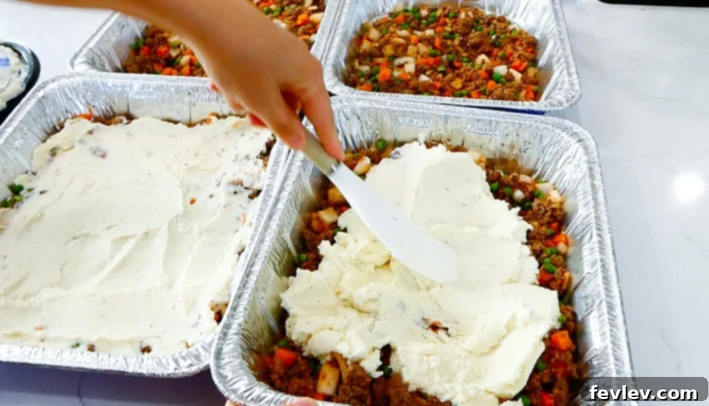 Beef broth, tomato paste, and frozen vegetables added to the ground beef mixture.