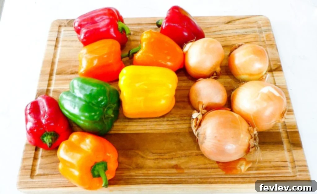 All ingredients for sausage and vegetables sheet pan meal mixed together in a bowl.