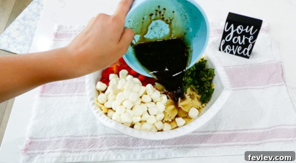 Fresh Caprese Pasta Salad with Zesty Balsamic 11 Tossing Caprese pasta salad with balsamic vinaigrette until fully coated.