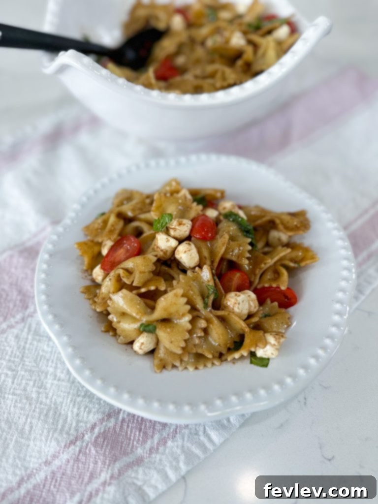 Fresh Caprese Pasta Salad with Zesty Balsamic 13 Delicious Caprese Pasta Salad garnished with fresh basil leaves, ready to be enjoyed.