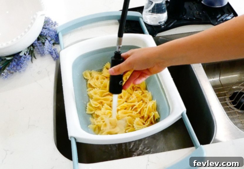 Fresh Caprese Pasta Salad with Zesty Balsamic 5 Draining cooked pasta in a colander.
