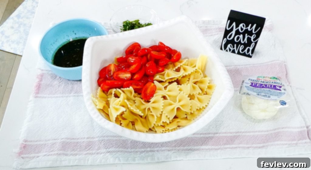 Fresh Caprese Pasta Salad with Zesty Balsamic 7 Adding cherry tomatoes and mozzarella pearls to cooked pasta.
