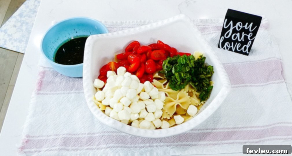 Fresh Caprese Pasta Salad with Zesty Balsamic 10 Pouring balsamic vinaigrette over the Caprese pasta salad.