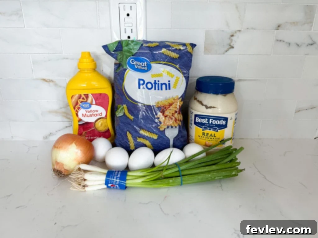 Creamy Deviled Egg Pasta Salad in a large serving bowl, garnished with paprika and green onions.