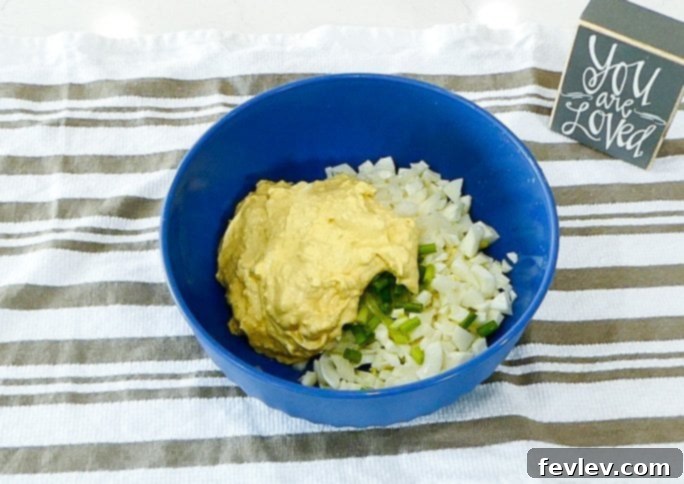 Deviled Egg Pasta Salad in a bowl with a serving spoon.