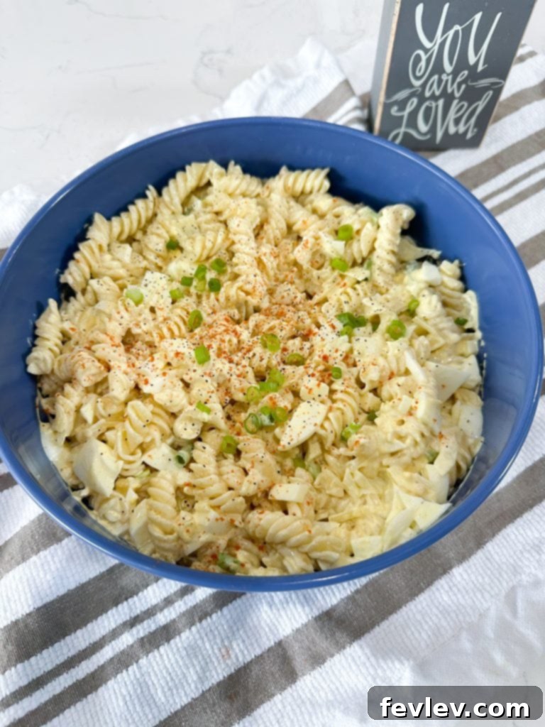 Close-up of deviled egg pasta salad ingredients being mixed.