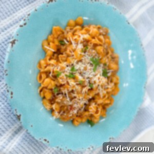 Delicious baked Italian Shells with Sausage, garnished with fresh parsley and Parmesan cheese