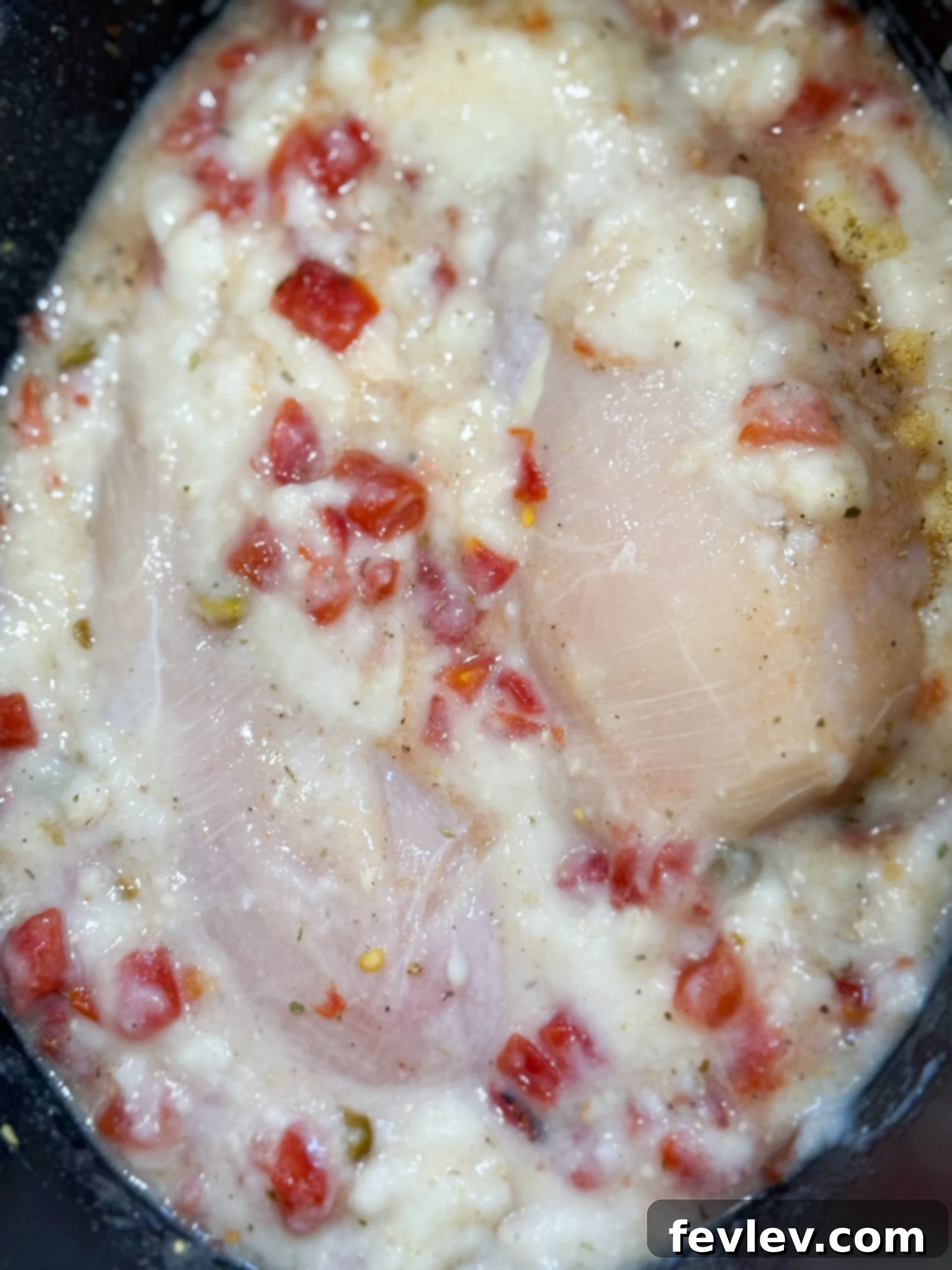 Velvety Slow Cooker Rotel Chicken Pasta 5 Raw chicken breasts, cream of chicken soup, and Rotel tomatoes in a slow cooker pot.