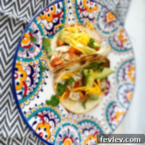Delicious Slow Cooker Salsa Verde Chicken served in a bowl, garnished with fresh cilantro and lime