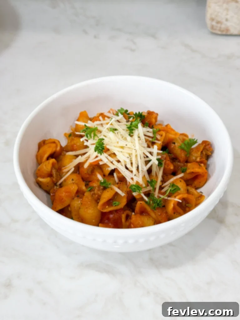 Speedy Skillet Sausage Pasta 5 Delicious one-pot sausage pasta served in a bowl, garnished with fresh herbs and a sprinkle of cheese.