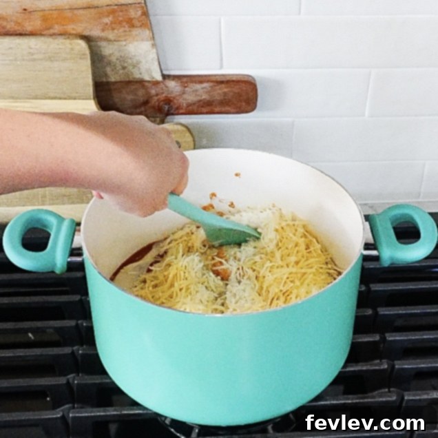 Effortless One Pot Creamy Pasta 4 Rich tomato and Alfredo sauce simmering gently in a large pot, creating a creamy base for the pasta.