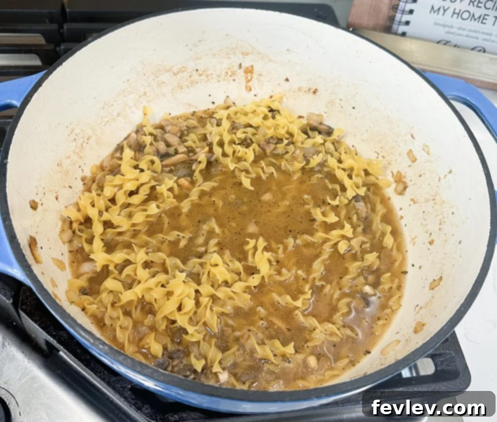 Quick & Creamy One-Pot Chicken Stroganoff 5 Egg noodles simmering in broth