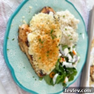 Longhorn Steakhouse style Parmesan Crusted Chicken, with a golden-brown crispy crust and rich cheesy topping, served with fresh herbs.
