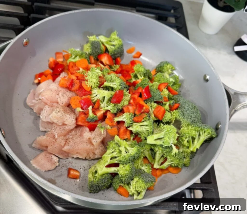 Effortless Chicken & Veggie Delight 2 Sizzling easy and flavorful chicken and vegetable stir fry in a large skillet with vibrant vegetables