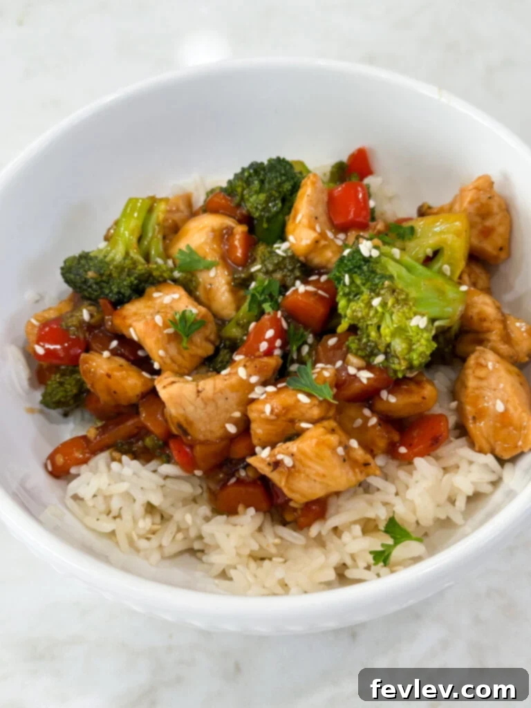 Effortless Chicken & Veggie Delight 5 Easy and flavorful chicken and vegetable stir fry plated with rice, garnished with green onions