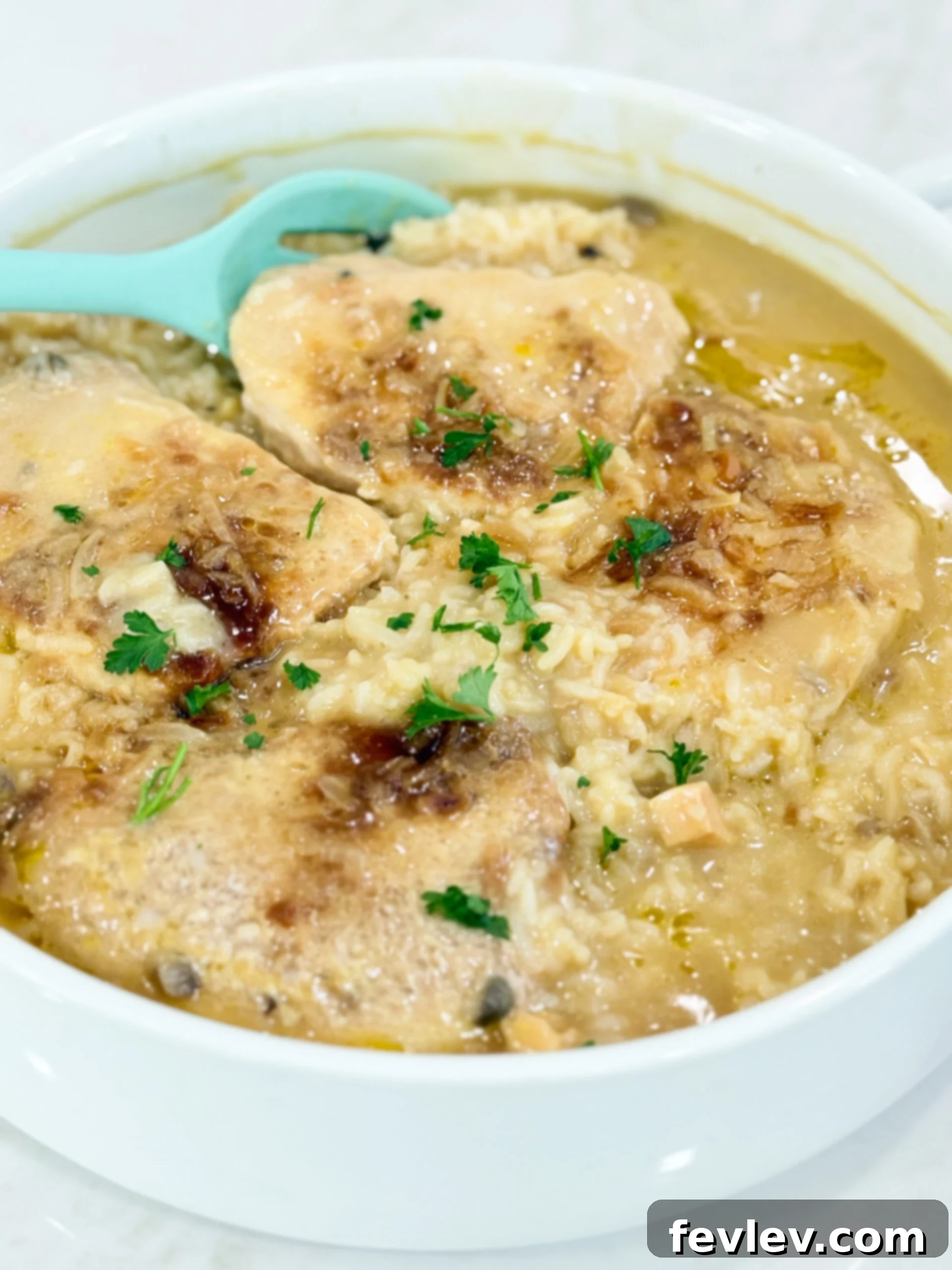 One-Pan Pork Chop Perfection 2 No Peek Pork Chop Casserole finished cooking in a round casserole dish, showcasing tender pork chops and creamy rice.