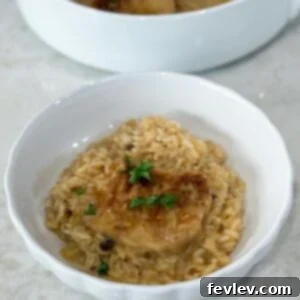 A serving of No Peek Pork Chop Casserole on a plate, featuring a pork chop and creamy rice.