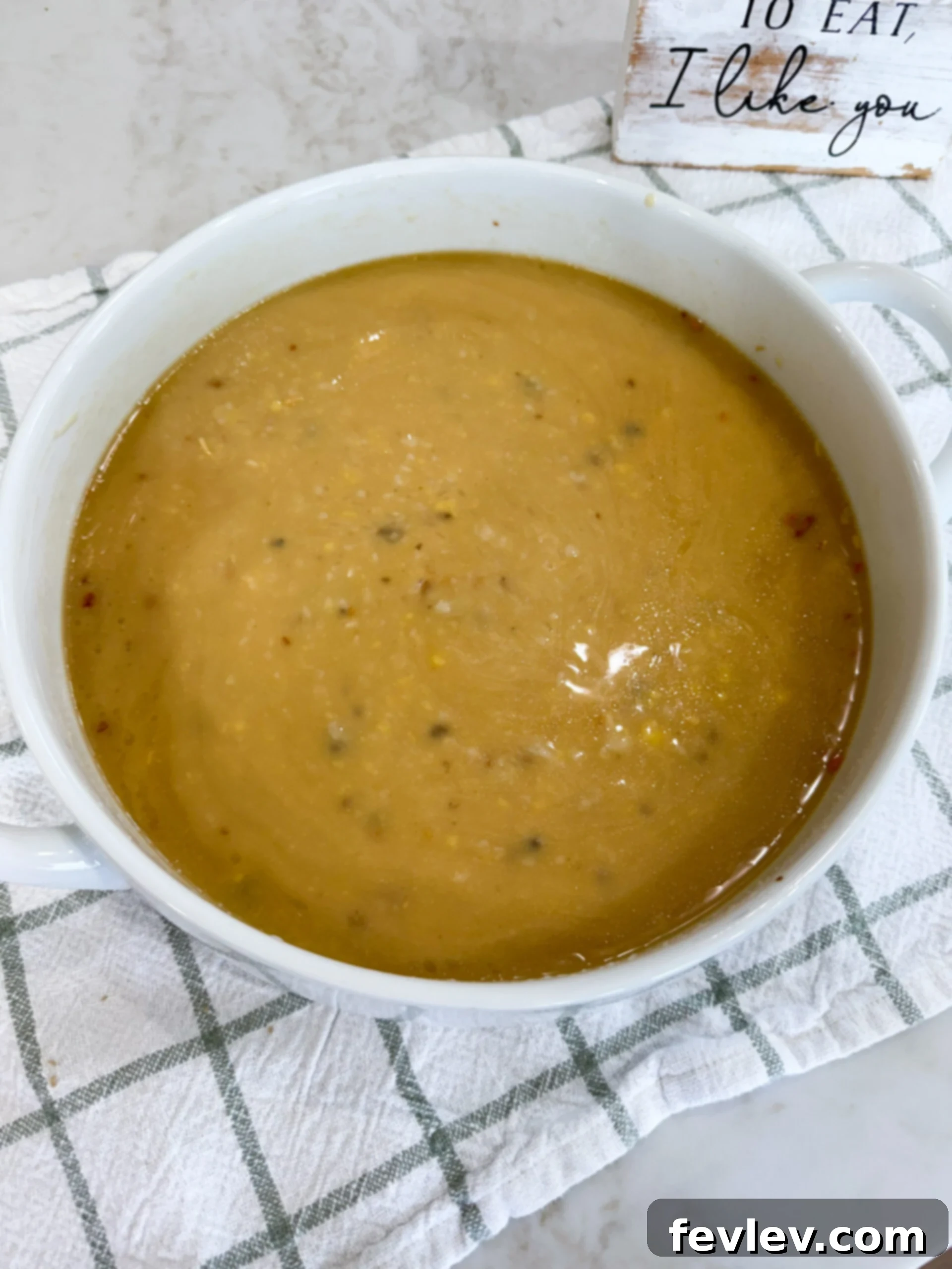 One-Pan Pork Chop Perfection 5 Rice, cream of mushroom soup, cream of chicken soup, chicken broth, and onion soup mix being whisked together in a 9x13 baking dish.