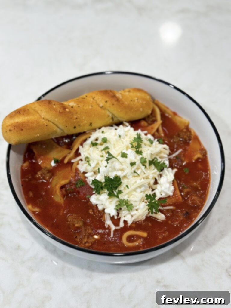 Bowl of lasagna soup topped with melted cheese