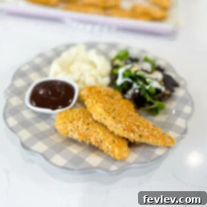 Crispy Baked Chicken Tenderloins - Golden brown chicken tenders on a baking sheet, ready to serve.