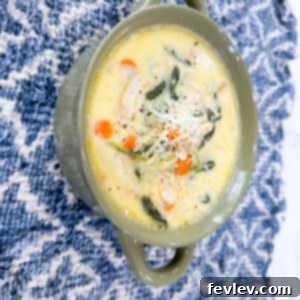 Delicious and comforting creamy chicken and pasta soup, garnished with fresh herbs.