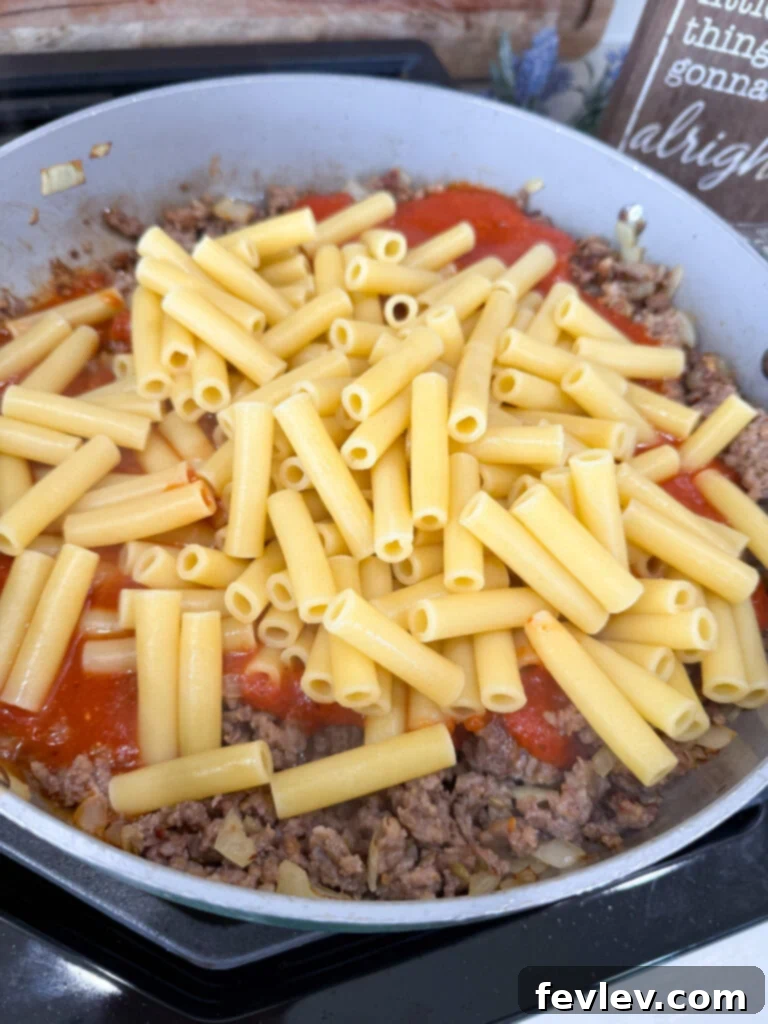 Ultimate Cheesy Baked Ziti 3 Cooking the sausage and onion for baked ziti