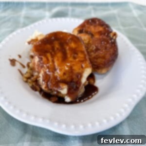 Delicious Slow Cooker Sticky Buns, golden brown and covered in gooey caramel sauce, with chopped walnuts visible.